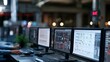 © Wuttichai - Control room with multiple computer monitors displaying technical schematics and system interfaces in a dimly lit industrial setting