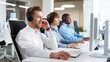© VAKSMANV - Caucasian joyful young man sitting in modern office wearing headset and talking in furniture while typing on computer looking at screen. People working in client support on background. Close up