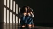 © oksa_studio - Sad woman sitting alone in darkness feeling depression and melancholy in solitude