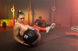 © Wavebreak Media - Diverse gym partners performing seated Russian twist on mats at gym holding 4 kg medicine ball