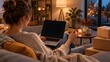 © Dreykon - Person shopping online at home with a laptop and credit card during evening