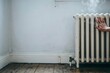 © happie - Hand testing a cold radiator in a bare room – Perfect for fuel poverty awareness, energy campaigns, or housing reports