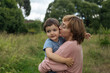 © Pietro Karras/Stocksy - Mother kissing son outdoors
