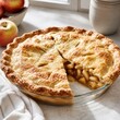 © Nadiia - Homemade apple pie with golden flaky crust and fresh apples in a bright kitchen