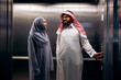 © Petro - Muslim couple wearing traditional clothing, a woman in hijab and a man in thawb and keffiyeh, using an elevator