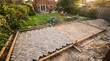 © MdZakirHossain - A residential garden patio under construction with herringbone pattern paving blocks being laid on a sand base