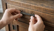 © Parveg - Person assembling furniture by attaching a dark metal handle to a wooden bedside table drawer with furniture assembly home improvement attaching restoration carpentry craftsman woodwork
