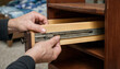 © Parveg - Person assembling a small wooden cabinet drawer by aligning the sliding runner tracks with wooden furniture sliding rail home improvement hardware assembly installation carpentry