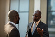 © Marko Geber - Two business professionals discussing outside office building
