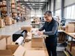 © cloud7days - Mature East Asian male packing shipping boxes with air pillows