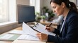 © Mukhliez - Focused female professional auditor reviewing a compliance checklist and policy documents in a modern corporate office.