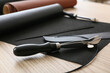 © Pixel-Shot - Leather craft and artisan hobby, professional tools for leatherworking with rolls of material on a wooden workbench in a workshop