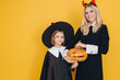 © anatoliycherkas - Mother and Daughter Wearing Halloween Costumes Holding Jack o' lantern