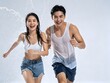 © aziseptian - Happy asian couple running through water splashes during songkran