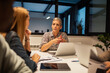 © Marko Geber - Businesswoman leading team meeting in modern office
