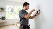 © Keenaan - Professional technician installing smart home thermostat on white wall