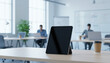 © parama diwa - Modern Tablet Stand in Bright Office with Team in Background