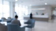 © Sabbir Designer - Person sitting in a modern hospital lobby waiting area with blurred background