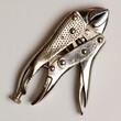 © Muhammad - Silver locking pliers with closed jaws resting on a plain light background
