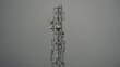 © deepshikha - Telecommunications tower amidst misty mountains with gray skies in Ladakh, India, winter season, early morning fog, high vantage point, industrial structure against cloudy backdrop