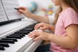 © Nik_aquaneon - Closeup child piano keyboard hands with sheet music and teacher guidance for music lesson and education background