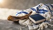 © Daria - Traditional Yom Kippur and Rosh Hashanah still life with a shofar horn, tallit prayer shawl, and a prayer book on a stone background with warm morning light.