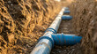 © Mahmuda - Laying blue PVC drainage pipes in ground trench | Underground plumbing and sewage system installation | Construction site water pipe drainage network | Industrial sewer pipe connection in excavated