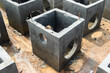 © vuthy - Square concrete drainage chambers positioned separately on sandy construction ground awaiting installation
