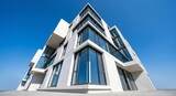 Modern minimalist architecture building with geometric design and glass facade under clear sky