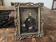 © Eyasin - Antique tintype portrait of a bearded man in an ornate metal frame on a table