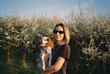 © Asya Molochkova/Stocksy - Woman Holding Cavalier Spaniel in Blooming Spring Orchard