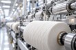 © Ruby - Close-up of fine cotton fibers being spun into smooth yarn on industrial machinery.