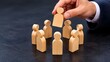 © HP - Hand placing wooden figure into a circle of people, concept of team building, recruitment, hiring, inclusion, and completing a corporate team for business success