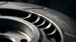 © Nawab - High-performance ventilated brake disc close-up. Slotted steel rotor for automotive racing. Industrial metal car part detail.