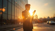 © happy - Businessman using smartphone at sunset with lens flare