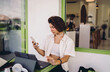 © BullRun - Smart tech integration flexible workflow allows Caucasian female freelancer multitask on smartphone near tablet computer at cafe workspace table, enjoying modern self-employment personal autonomy