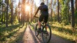© dmmarychev - Man riding mountain bike on trail in pine forest at sunset