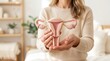 © Artful Stock - Close up of hands holding a female reproductive system model for gynecological health and cancer awareness.
