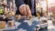 © 현욱 김 - Businessman placing wooden blocks on a world map in a warehouse, symbolizing global logistics, supply chain management, and risk management.
