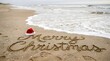 © Purple 3 - A festive 'merry christmas' message is written in the sand on a beautiful beach shoreline