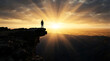 © Shanta - Silhouette of Person Standing on Cliff Edge Facing Glorious Sunrise Rays