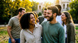 © musab - Group of diverse young friends laughing and walking together in a sunny park