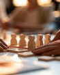 © The Little Hut - Diverse team collaborating and strategizing with wooden figures on a tabletop game during a meeting