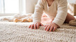 © Olivia - Baby hands touching soft knitted rug on living room floor