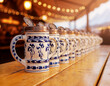 © MollaMohammad - Row of traditional Bavarian beer steins on a wooden table at Oktoberfest