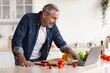 © Prostock-studio - Smiling Elderly Caucasian Man Cooking Fresh Vegetables In Kitchen While Following Recipe On Laptop. Enjoying Cooking Experience, Engaging In Healthy Meal Preparation At Home. Weight Loss Concept.