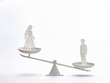 © Krisna - Gender pay gap and wage inequality concept featuring paper cutout male and female figures on a wooden balance scale for International Equal Pay Day campaigns, isolated on white background