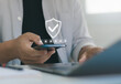 © MUNTHITA - Person entering password on smartphone with shield icon secure login interface, representing OTP verification, MFA authentication, cyber security, identity protection, encrypted mobile access. 2FA.