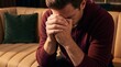© Art Revolutionist - Depressed man sitting on a sofa covering his face with his hands