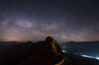 © tai - Ancient fortification on a mountain peak under a clear, star-filled night sky, with distant landscape lights.